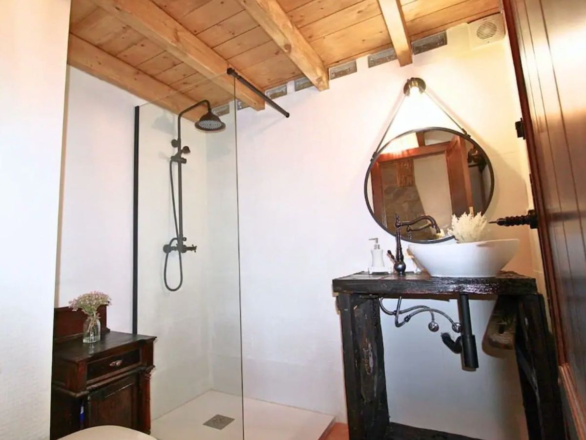Segundo baño de la casa, con ducha y techo de madera
