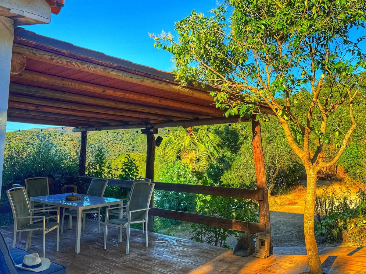 Porche con mesa y sillas de exterior bajo la pérgola