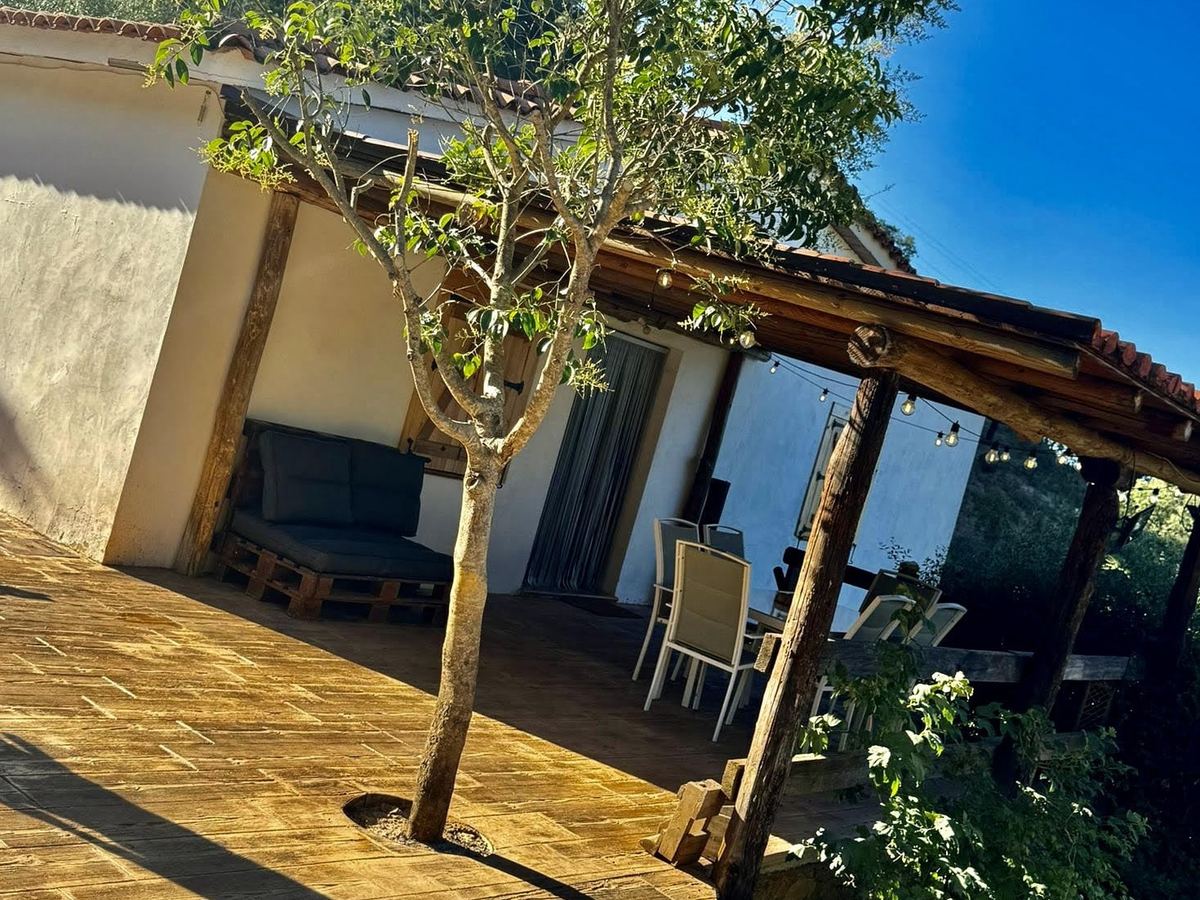 Porche con pérgola de madera junto a la fachada de la casa