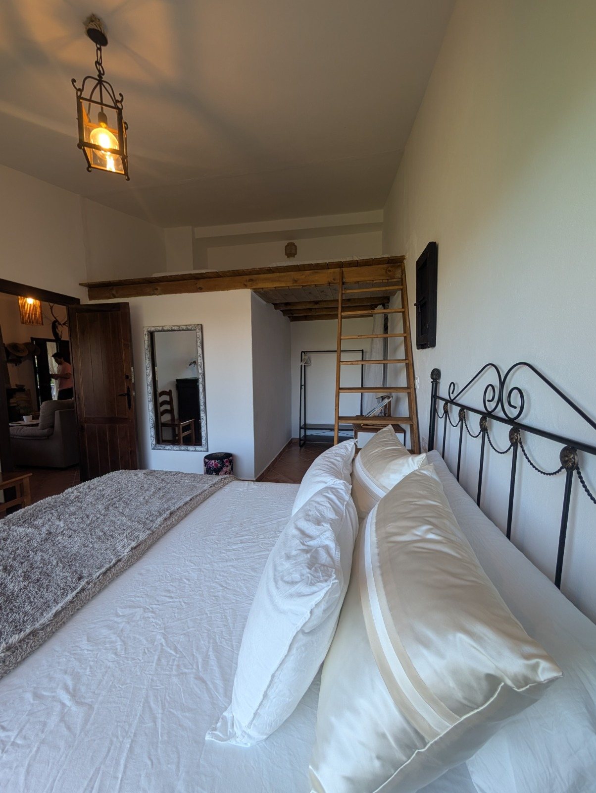 Escalera de madera de acceso al altillo, vista desde la cama de la habitación del ventanal
