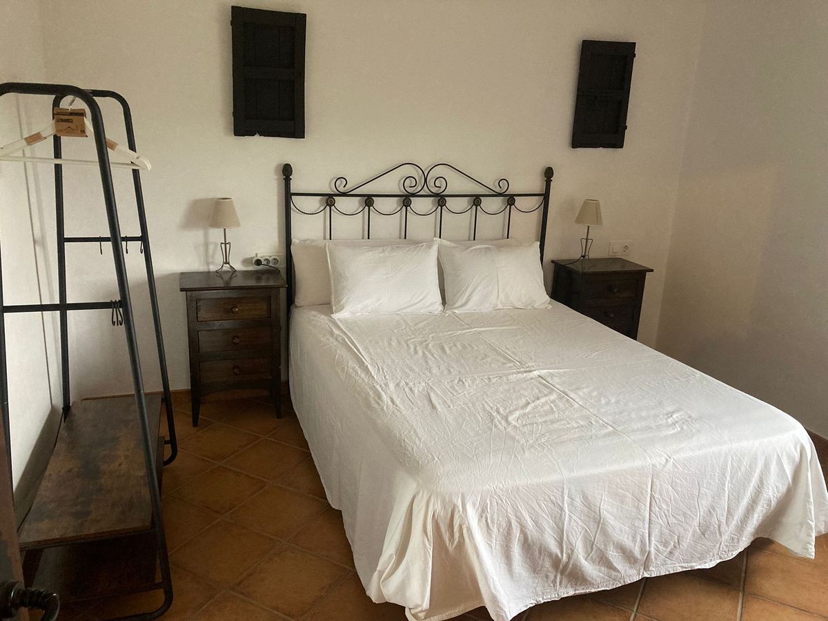 Dormitorio con cama de matrimonio, mesillas y lámparas de lectura