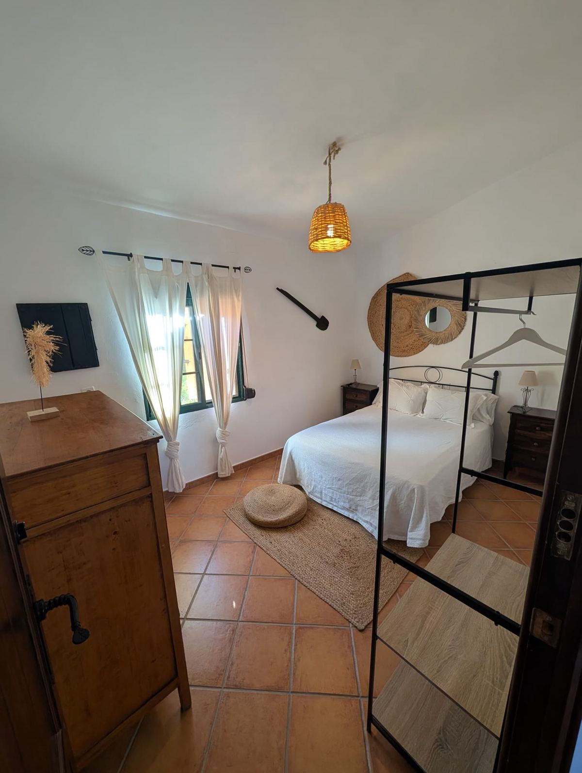 Dormitorio luminoso con cama de matrimonio y ventana al jardín